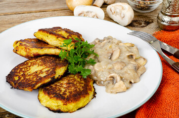 Wall Mural - Fried grated potato pancakes with mushroom sauce. Studio Photo