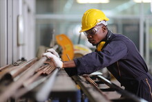 African American Mechanic Engineer Worker Is Choosing Copper Tube For Sawing While Working In Coolant Factory With Copy Space