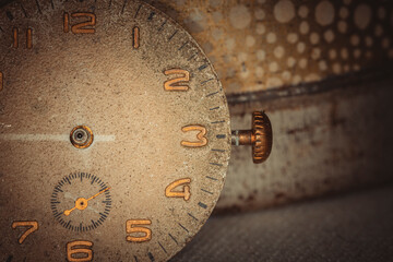 Vintage grunge background of an old clock. Abstract texture covered with dust, dirt, scratches. Macro photography in light tinted