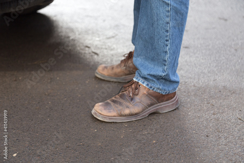 Man's legs in blue denim jeans and brown boots. © indigolotos