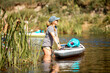 © Uldis Laganovskis - A young athletic woman holds a SUP stand up paddle board in the river. Side view