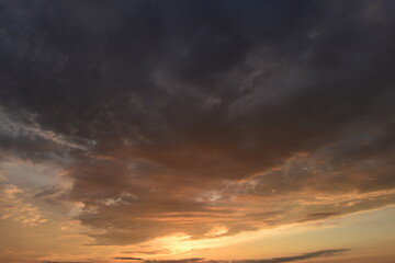 Wall Mural - Scenic cloudy sky in the glowing of the sun in the sunset