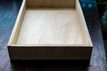 assembles wooden drawers of new furniture in the workshop.