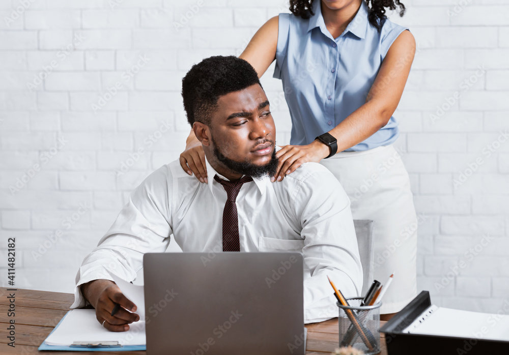 Lady boss sexually molesting her attractive male subordinate, putting hands on his shoulders at company office - obrazy, fototapety, plakaty 