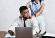 © Prostock-studio - Lady boss sexually molesting her attractive male subordinate, putting hands on his shoulders at company office
