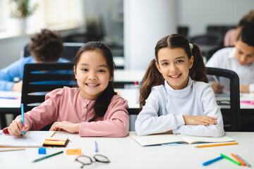 Poster - Portrait of small girls sitting at desk in classroom