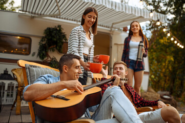 Wall Mural - friends sing songs with guitar, picnic at camping