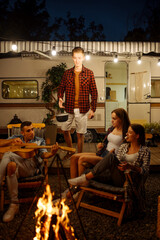 Wall Mural - friends cooking in pot on campfire, camping