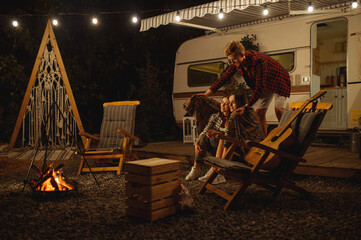 Wall Mural - man covers girlfriends in plaid by the campfire
