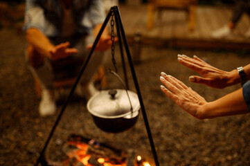 Wall Mural - friends warming their hands by campfire, camping