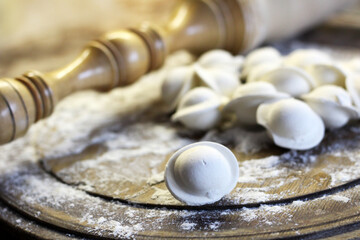 Traditional pelmeni or dumpling at cutting board. Homemade preparation food.