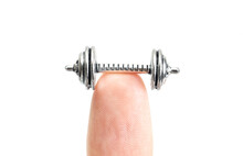 Cropped view of a tiny dumbbell on a fingertip isolated on white