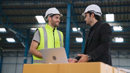 Wall Mural - Two factory workers working and discussing manufacturing plan in the factory . Industry and engineering concept .