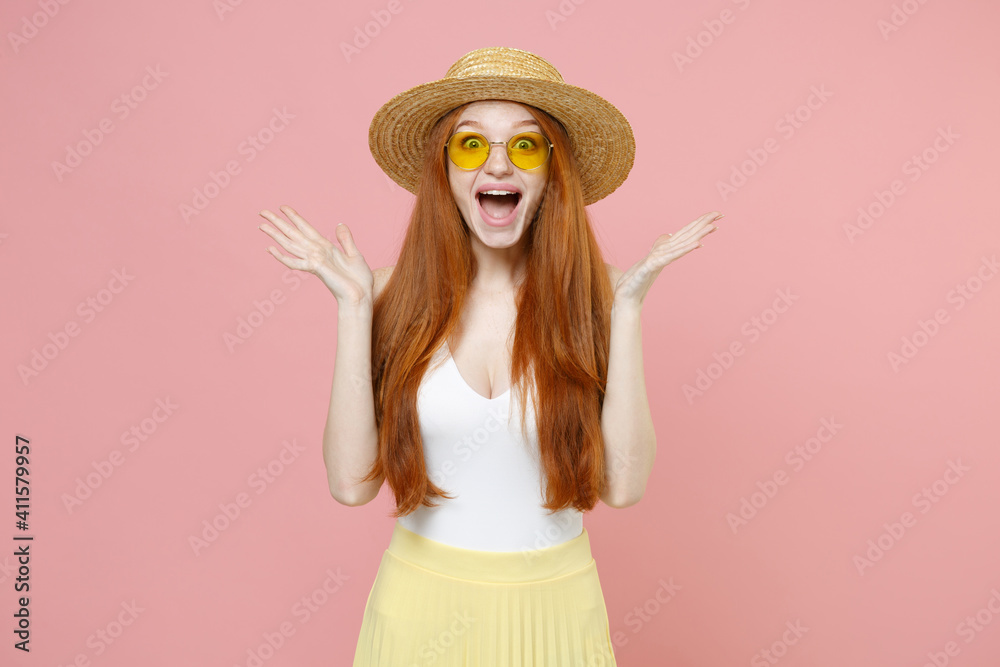 Young smiling shocked excited surprised caucasian nice redhead woman 20s ginger long hair wearing straw hat glasses summer clothes looking camera isolated on pastel pink background studio portrait. - obrazy, fototapety, plakaty 