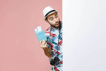 Wall Mural - Shocked young traveler tourist man in summer clothes hat hold big white empty blank billboard passport tickets isolated on pink background. Passenger travel on weekends. Air flight journey concept.