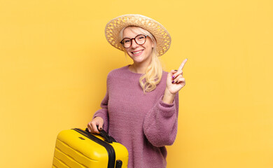 Wall Mural - blonde woman smiling proudly and confidently making number one pose triumphantly, feeling like a leader