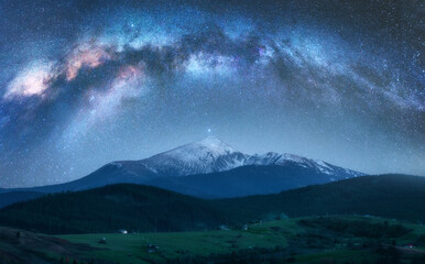 Wall Mural - arched milky way over the beautiful mountains with snow covered peak at night in summer. colorful la