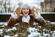 © Alliance - woman outside in city park in winter showing snowy mittens