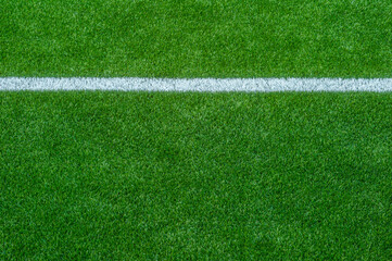 Green synthetic grass sports field with white line shot from above. Soccer, rugby, football, baseball sport concept