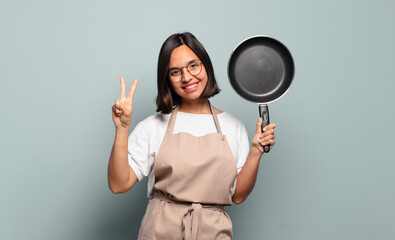 Canvas Print - young hispanic woman smiling and looking friendly, showing number two or second with hand forward, counting down