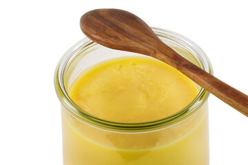 homemade ghee in jar and wooden spoon . ghee is purified butter. isolated on white background.