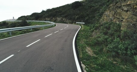 Wall Mural - Empty long mountain road to the horizon on a sunny summer day at bright sunset - aerial drone shot