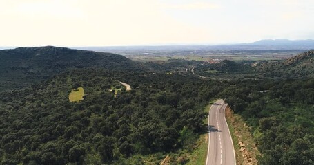 Wall Mural - Empty long mountain road to the horizon on a sunny summer day at bright sunset - aerial drone shot