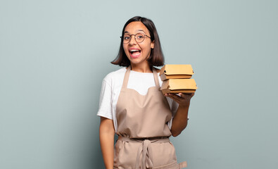 Wall Mural - young hispanic woman looking happy and pleasantly surprised, excited with a fascinated and shocked expression