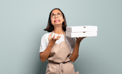 Wall Mural - young hispanic woman looking desperate and frustrated, stressed, unhappy and annoyed, shouting and screaming