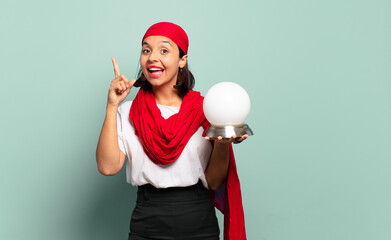 Wall Mural - young latin woman feeling like a happy and excited genius after realizing an idea, cheerfully raising finger, eureka!