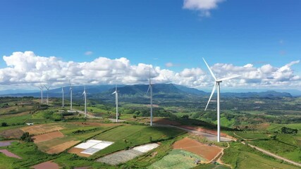 Wall Mural - Aerial view of Powerful wind turbine farm for alternative energy production on clouds blue sky warm summer at highland. Cenerating clean renewable energy for sustainable development
