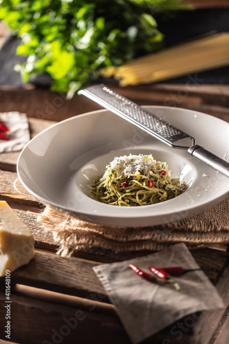 Spaghetti aglio e olio with olive oil, gralic, basil, parmesan cheese, tomatoes and chillies served in a deep plate © weyo