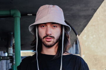 man with long hair and a beard, wearing bucket hat