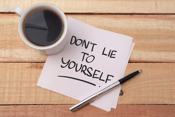 Dont lie to yourself, text words typography written on paper against wooden background, life and business motivational inspirational