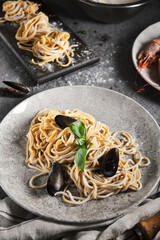 Wall Mural - Home made pasta with seafood and green leaf. Gray vintage table and cloth. Tasty pasta with mussels