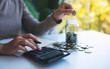 © Farknot Architect - Closeup image of a woman putting coins in a glass jar and calculating on calculator for saving money and financial concept