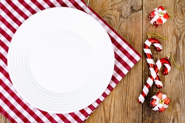 Wall Mural - Christmas and New Years concept. White plate, red tablecloth. Studio Photo