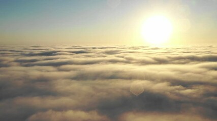 Wall Mural - striking aerial view of the sunset sky with the clouds below us. the shadows projected from the sun 