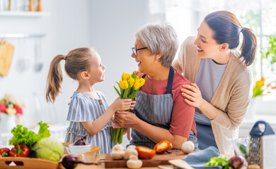 Wall Mural - Granddaughter is giving flowers to her grandmother