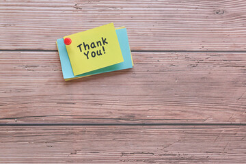 Thank you note pin on wood wall.