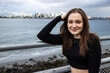 © Mat Hayward - Teenage girl outside at Alki Beach in West Seattle with a view of the Puget Sound and the city of Seattle in Washington State.