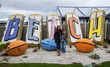 © Mat Hayward - Mother and teenage daughter in front of a large Beach sign