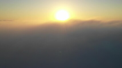 Wall Mural - striking aerial view of the sunset sky with the clouds below us. the shadows projected from the sun 