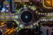 Top down overhead aerial view of moving car traffic at roundabout Vehicle road traffic around Selamat Datang monument in Jakarta, Indonesia at night