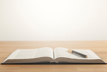 Wall Mural - Open Bible book on a wooden table.