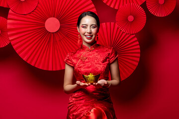 Wall Mural - Asian woman holding Chinese gold ingot for Chinese new year