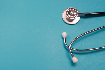 Medical stethoscope on light blue background. Medicine and healthcare concept. Top view, copy space