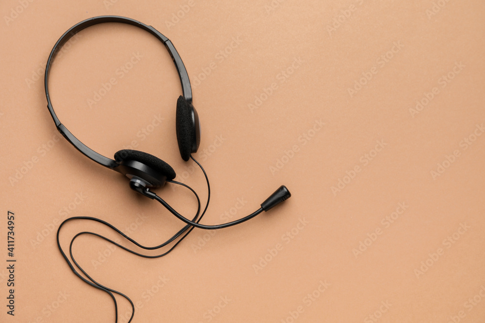 Headphones with microphone on color background