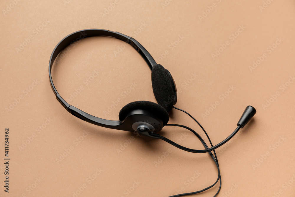 Headphones with microphone on color background