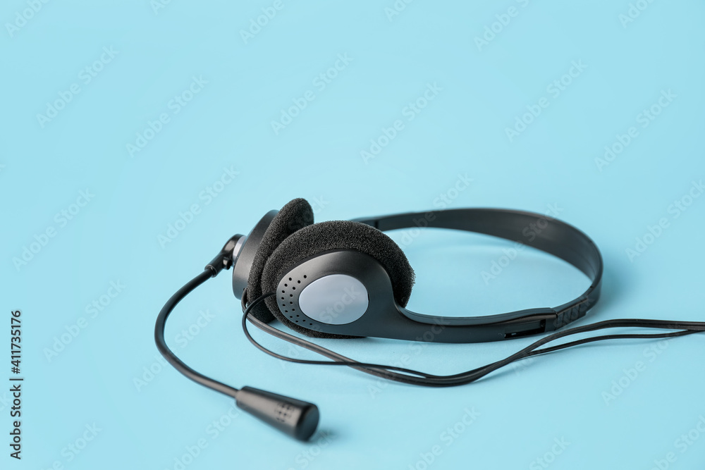 Headphones with microphone on color background